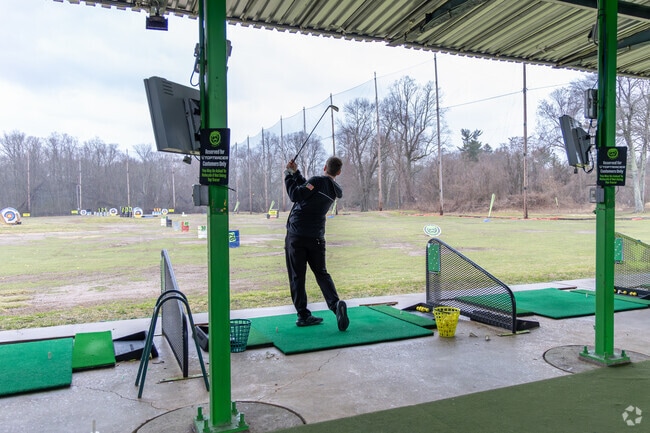 Golfers practice at the Southampton driving range, open daily rain or shine.