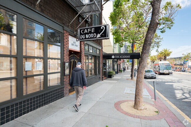 Man walks past Cafe Du Nord and The Academy, social venues in Duboce Triangle.