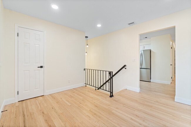 Stair landing featuring coat closet