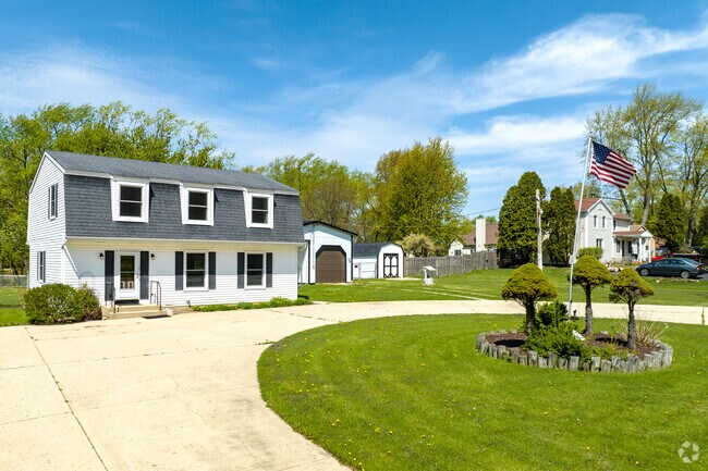Dutch Colonial Revival home style with wood siding is located in Keeneyville