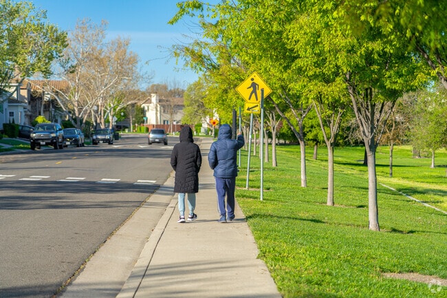 A couple enjoys a beautiful morning walk around the perimeter of Regency Community Park.