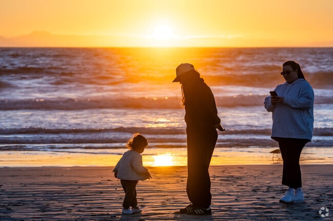 People enjoy the radiant sunsets on the beach at Central Newport Beach.