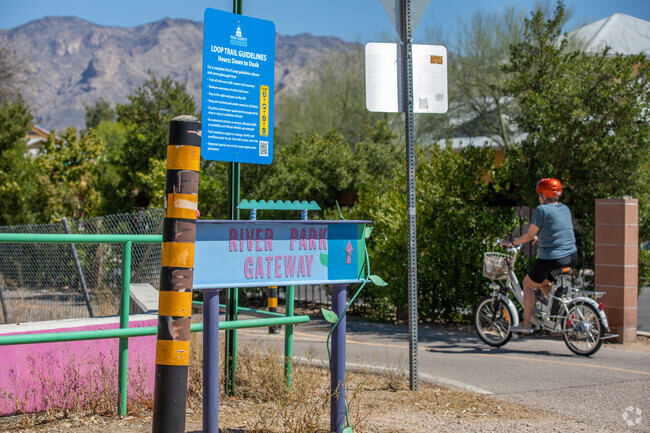 A Biker Takes A Leisurely Ride Along The Rillito River Park Pathway