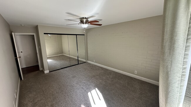 Carpeted bedroom with mirrored closet