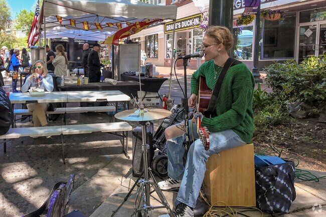Singing while playing guitar, cahon, and high hat makes for a fantastic performance.