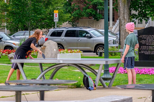 Two friends enjoy a game of ping pong in Bronson Park, located in the Central Business District.