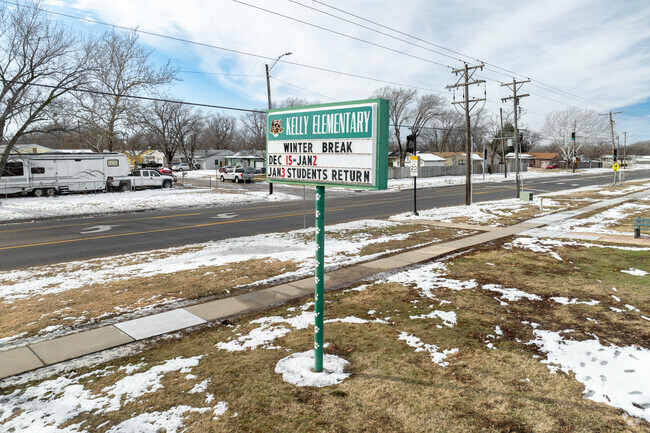 There is a sign for Kelly Liberal Arts Academy near the main road.