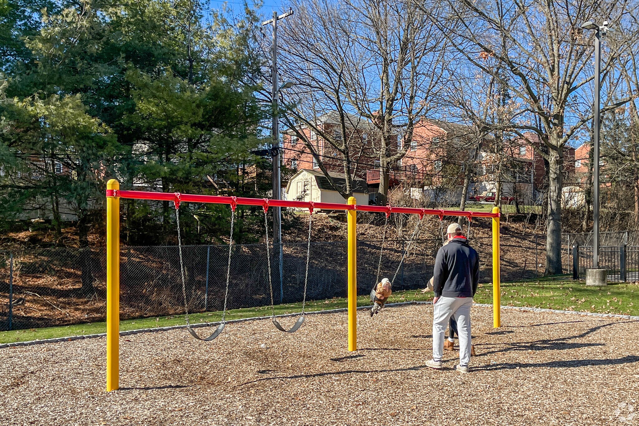 A young couple enjoys the sunshine and swings at Hale Park.