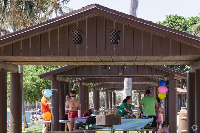 A family celebrates with a picnic under the pavilions in Jupiter Dunes.