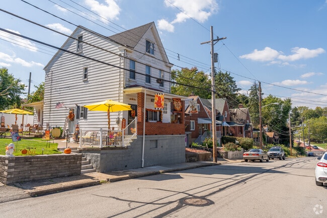 Tall Stick-style homes with a beautiful side yard overlook St. Clair.