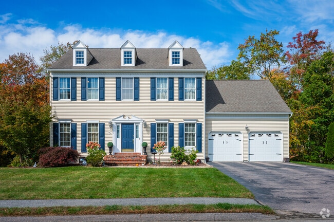 Two-story colonial revivals in Plainville often have an attached garage.