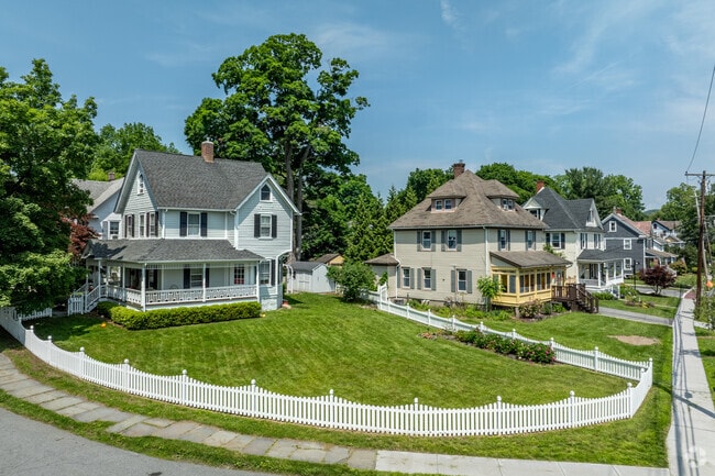 Charming early-1900s homes with fenced yards line village streets in Warwick, New York.