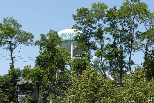 The East Farmingdale water tower can be seen through the trees within the neighborhood.