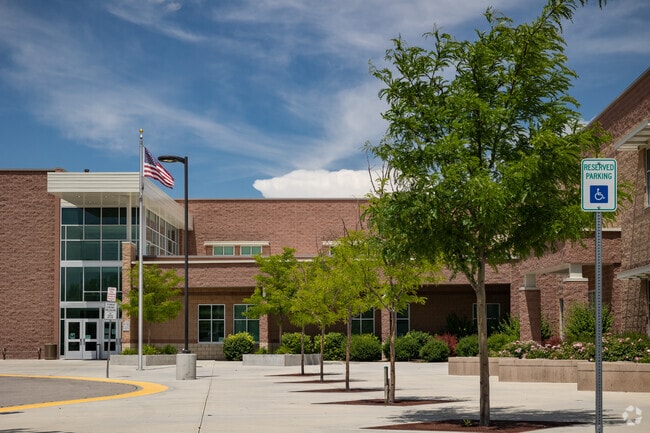 Victory Middle School main with entrance with flag and trees.