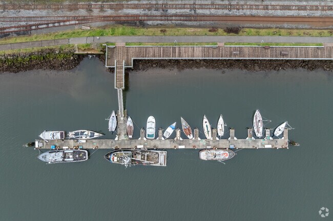The Coos Bay Boardwalk is a popular spot for people to walk alongside docked boats.
