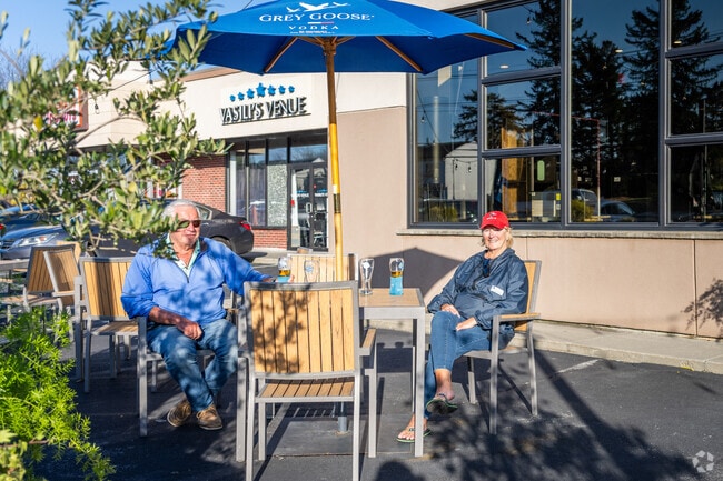 A couple enjoys drinks on a sunny day at the front outdoor seating of Agoro's Pizza in Somerset.