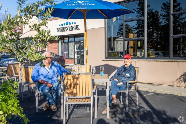 A couple enjoys drinks on a sunny day at the front outdoor seating of Agoro's Pizza in Somerset.