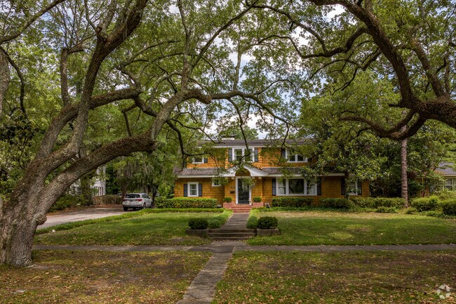 A cedar shingle home sits under moss-covered oak trees in Forest Hills South.