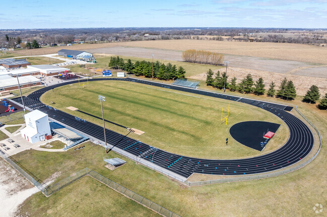 The football field and track are adjacent to the school to the east.