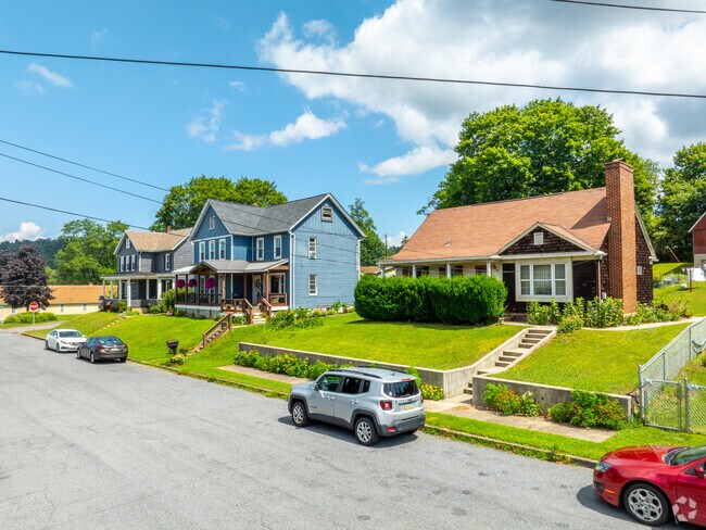 Sidewalk runs past a mix of cottage and new traditional homes with well-kept landscaping.