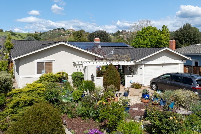 This California Ranch home in Shadow Brook features a pergola entry and lush, pollinator-friendly landscaping.