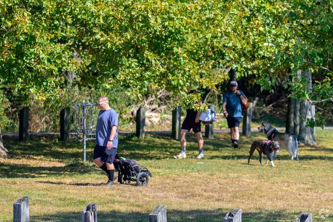 A group of disc golfers play a game at Spring Valley Park next to Eastwood.