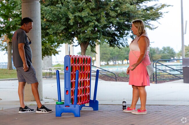 Visitors play games during a live concert at Hot Harbor Nights in Downtown Racine. .