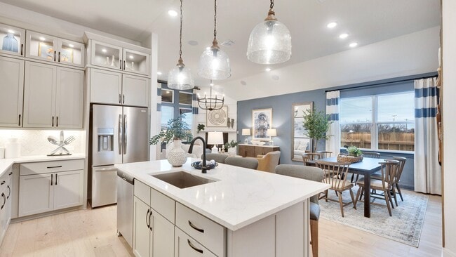 Spring Creek home with marble-topped island, custom cabinetry, and designer pendant lighting.