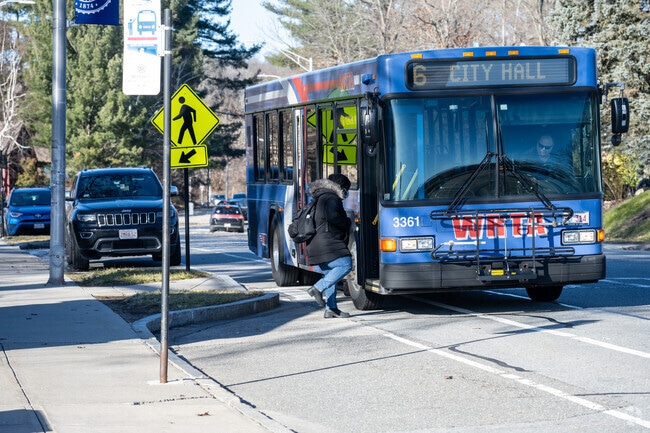 Woman gets on Worcester City bus outside Worcester State University.