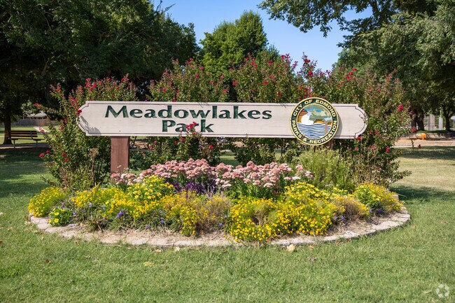 The entry to Meadow Lakes Park greets visitors with a large wooden sign.