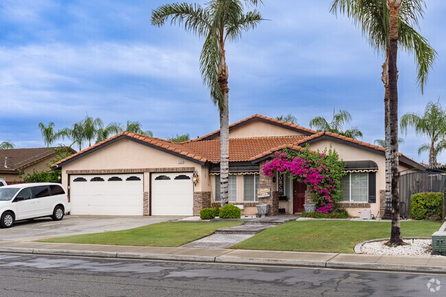 This late 20th century Spanish style inspired home has large palm trees in Olive Drive Area.