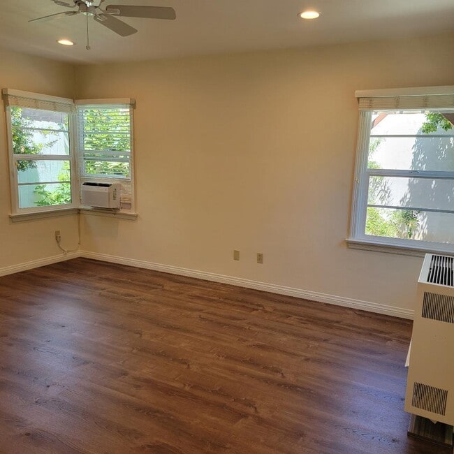 Bedroom showing wall heater and window air conditioner and 3 of the 5 windows