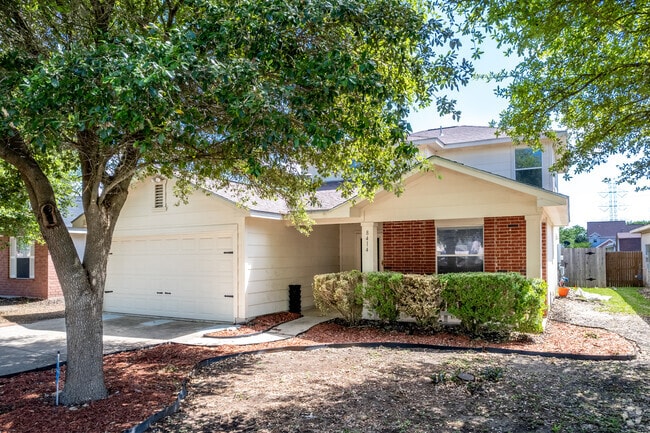 Cozy two-story house with a shaded yard in Converse, Texas.