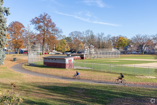 A group of kids ride their bikes through the Shedd Park in Lowell, MA.