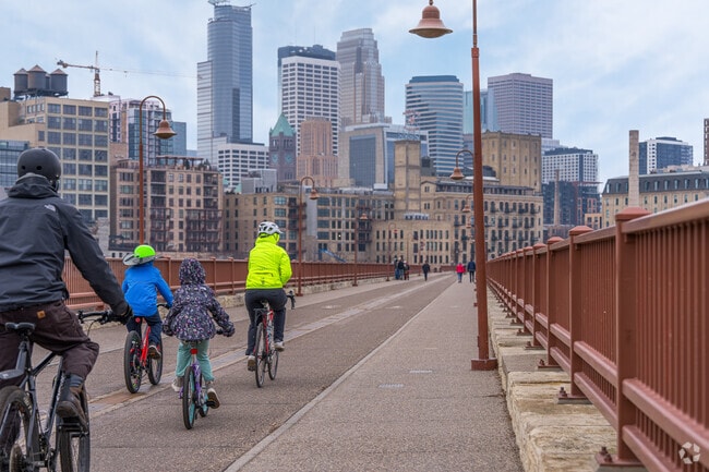 A family bikes across the Stone Arch Bridge near Downtown East.