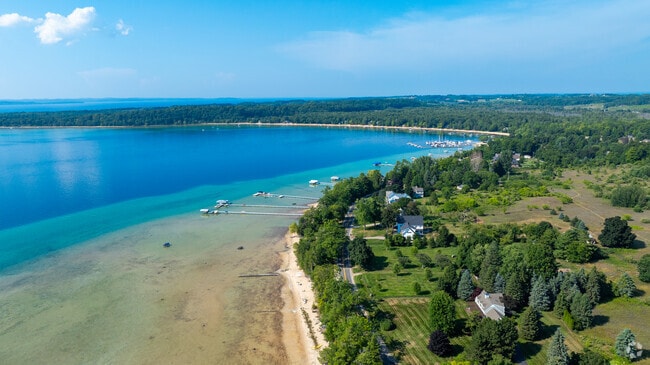 Clear waters and tree-lined shore frame a quiet marina on Grand Traverse Bay’s West Bay.