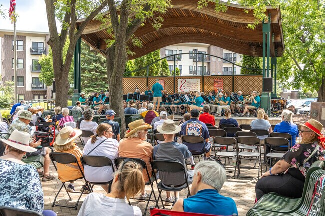 Attendees enjoy the Hopkins Raspberry Festival performances at Downtown Park.