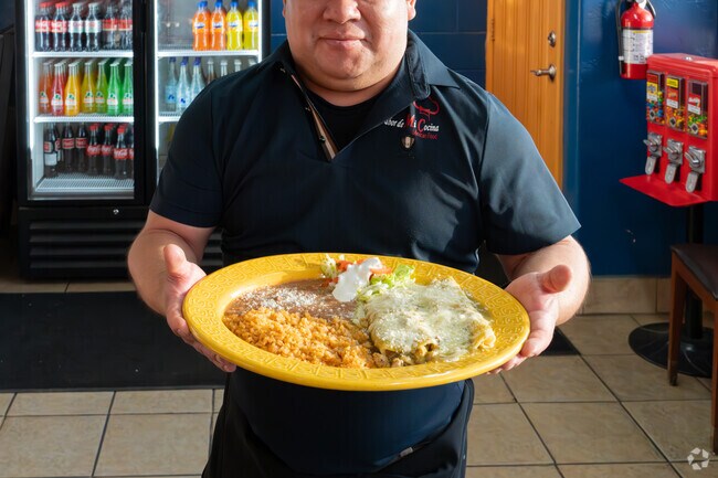 The owner of El Sabor de Mi Cocina in Lindsay proudly serves his delicious enchilada dinner.