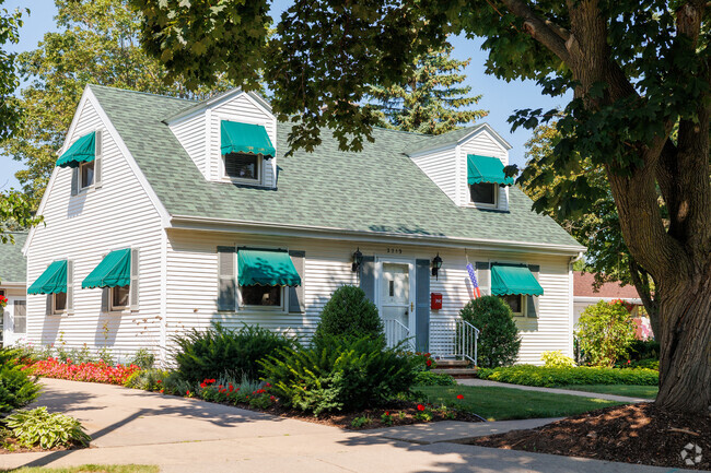 An older construction home in Huntley Houses is adorned with bright awnings.