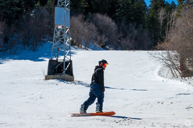 A Tijeras snowboarder enjoys the snow on a sunny day at Sandia Peak Ski Area nearby.