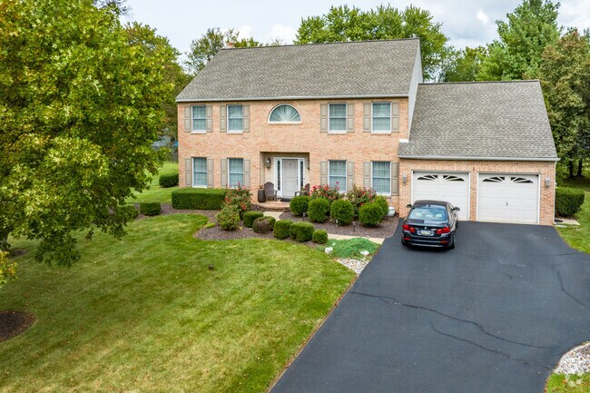 Traditional two-story homes in Hatfield are surrounded by trees.