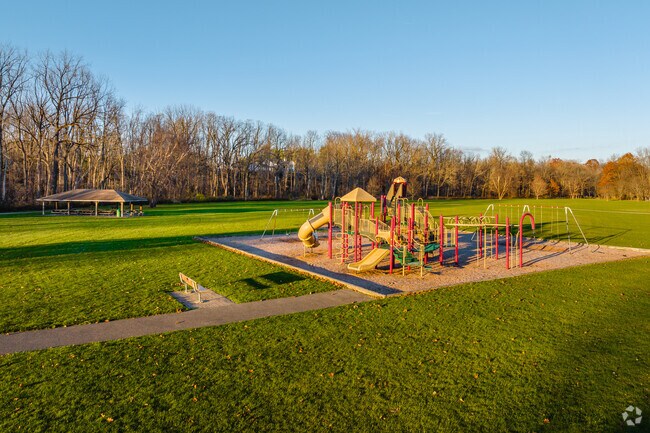 Village Green Park features an expansive field with walking paths and a playground in Elma.