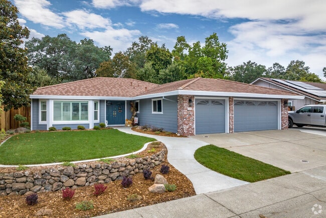 This traditional ranch-style home has a brick facing and raised bed lawn in Central Rocklin.