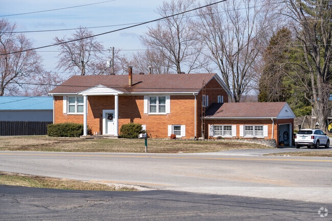Residential streets are lined with lush green lawns and large-bowed trees.