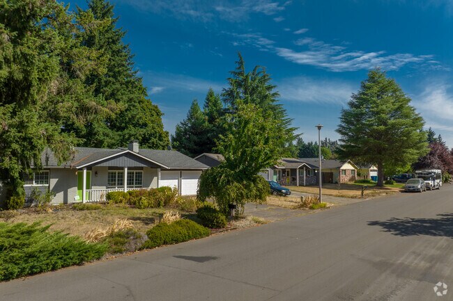 Towering pines shade ranch homes in Image, creating a serene forest vibe.