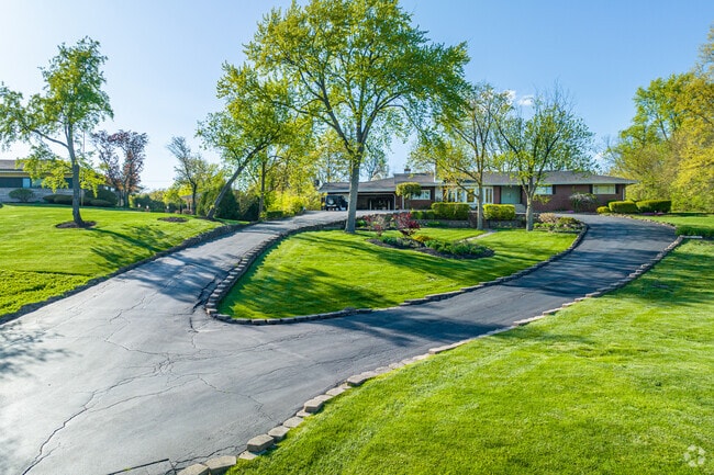This Ranch style home sits on top of a hill with a spacious yard and a looped driveway for convenient entrances and exits.
