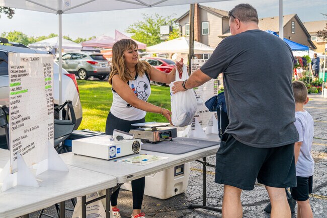 A father and son purchase a pound of fresh fish at the Oswego Country Market.
