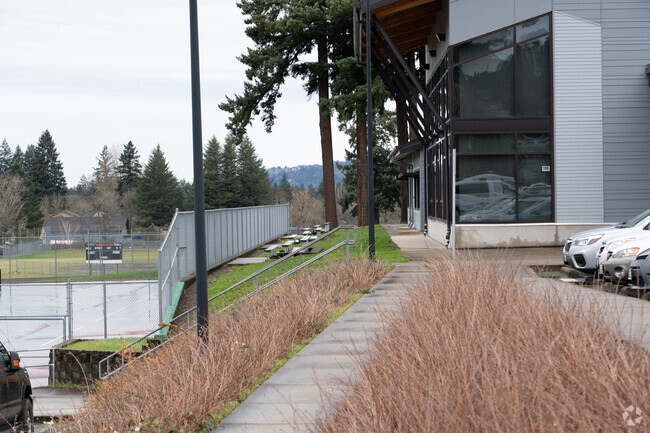 A paved path leads to bleachers to view the tennis courts.
