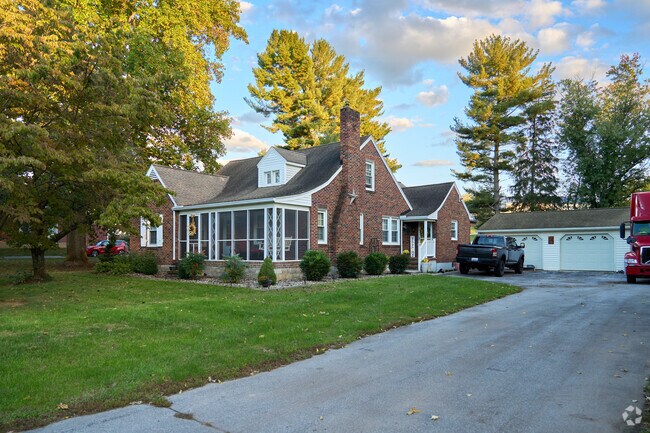 A large Cape Cod-style home sits on a large wooded lot in central Leitersburg