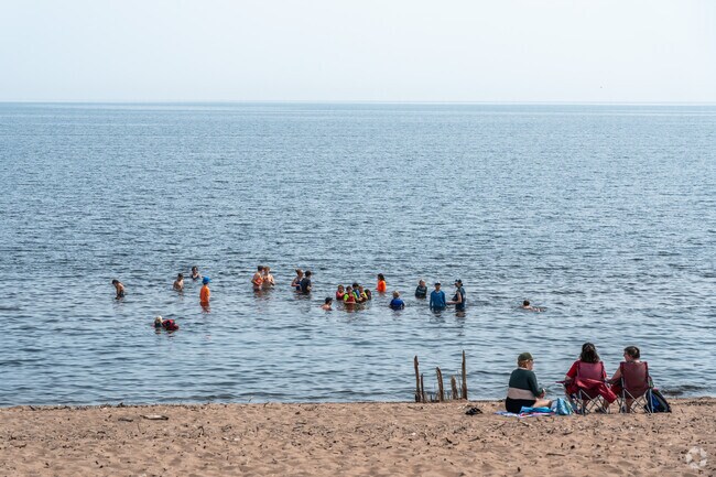 A group of people swim and hang out in Lake Superior at Park Point Beach.